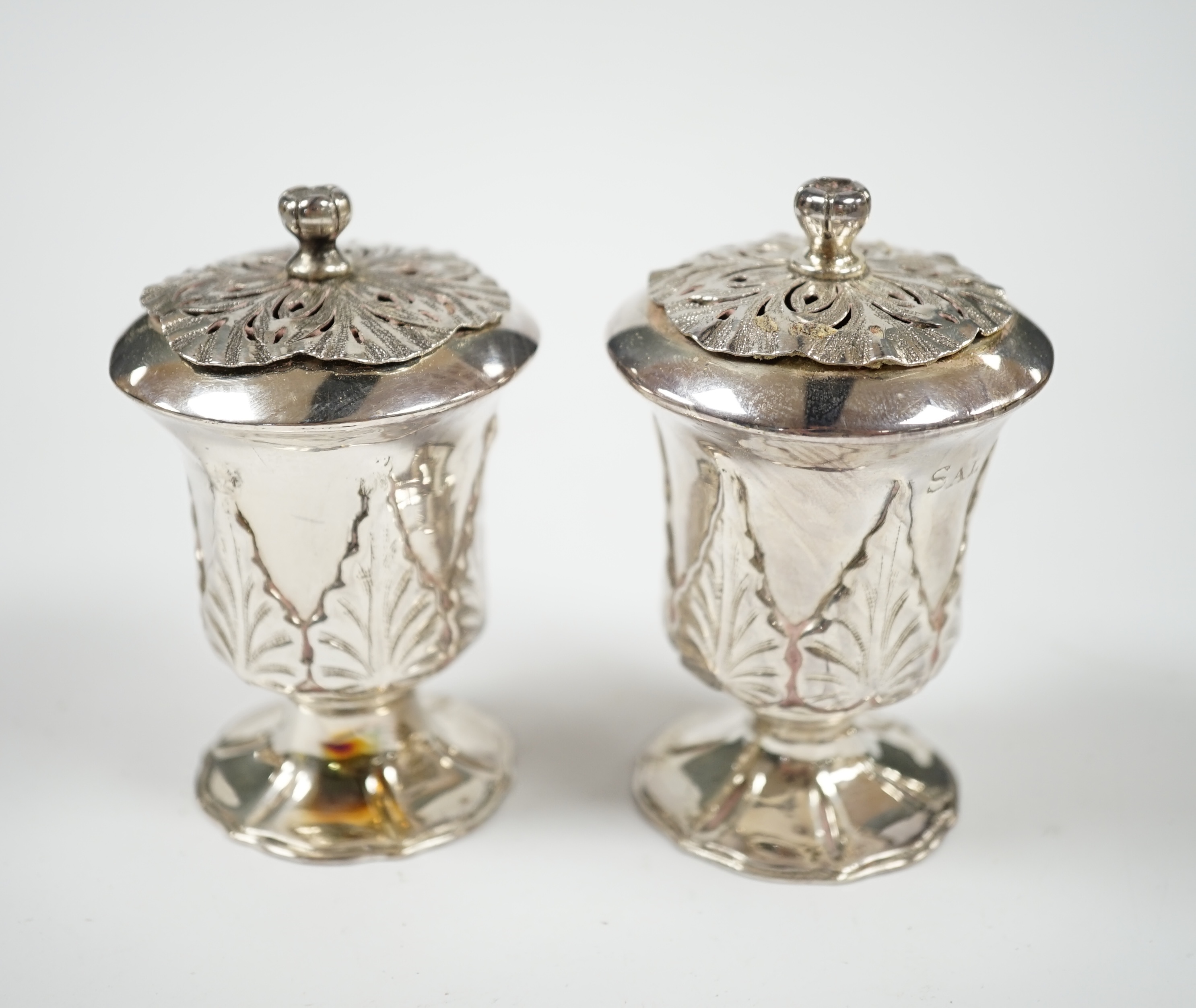 A pair of Indian? white metal condiments by Lattey Brothers & Co?, with acanthus leaf decoration, 83mm. Condition - fair